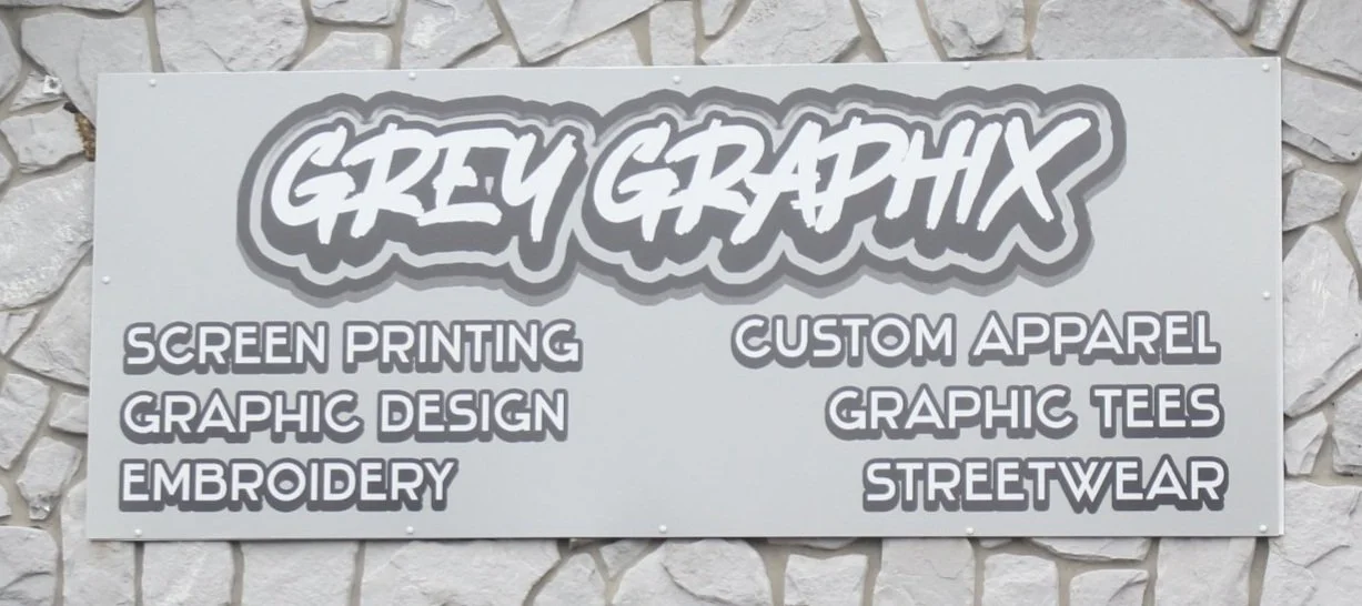 Grey Graphix sign offering screen printing, custom apparel, embroidery, graphic tees, and streetwear services